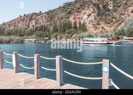 Des bateaux de croisière et des ferries avec drapeaux turcs transportent les touristes À l'émerveillement naturel de la Turquie méditerranéenne - Dalyan rivière Delta et l'ancien Banque D'Images
