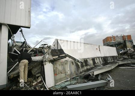 Un homme observe les ruines d'un entrepôt textile chinois qui a été incendié le 5 novembre 2005, lors de la 12e nuit des émeutes dans la banlieue parisienne du Bourget. De petits groupes mobiles de jeunes ont incendié des centaines de voitures supplémentaires et les violences et les attaques incendiaires qui ont secoué la banlieue de la capitale pendant une semaine se sont répandues dans d'autres villes françaises. Photo de Mehdi Taamallah/ABACAPRESS.COM Banque D'Images