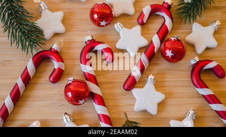 Pendentifs de Noël, cannes de bonbons et étoiles et boules d'arbre de Noël en rouge et blanc, branches de sapin, gros plan Banque D'Images