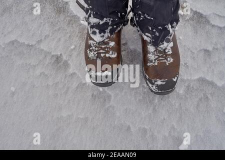 Bottes de randonnée brunes avec guêtres sur sol gelé Banque D'Images