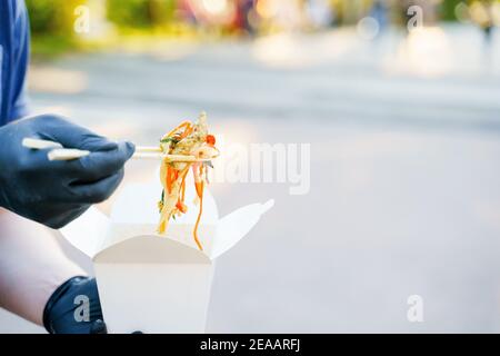 Gros plan les notes sur un arrière-plan flou sortent de la boîte blanche. Faites de la publicité pour la livraison au restaurant japonais. Restez à la maison et mangez des nouilles udon wi Banque D'Images