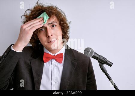 homme sueur a peur de la mauvaise présentation. homme stressé avec microphone, haut-parleur public en costume isolé sur fond blanc. le mec maud a peur Banque D'Images