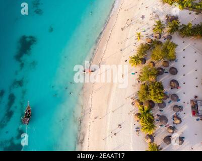 Vue aérienne des parapluies de toit de chaume modèle sur la large ligne côtière de sable blanc de la plage de Kendwa dans le village de Kendwa, Zanzibar Banque D'Images