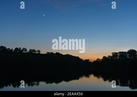 crescent Moon, planète vénus et le mercure au-dessus du lac au coucher du soleil, Weinfelder Maar, Allemagne, Daun, Banque D'Images