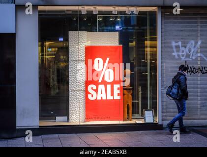 Essen, région de la Ruhr, Rhénanie-du-Nord-Westphalie, Allemagne - vitrine d'un magasin de mode à l'heure de Noël avec des offres spéciales, passant avec masque de protection dans le centre-ville d'Essen en temps de crise corona pendant le second confinement. Banque D'Images