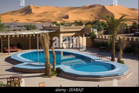 Hôtel et piscine dans le désert à Merzouga Banque D'Images