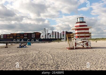 Un bateau à conteneurs entièrement chargé passe par South Beach, Miami Beach, Floride Banque D'Images