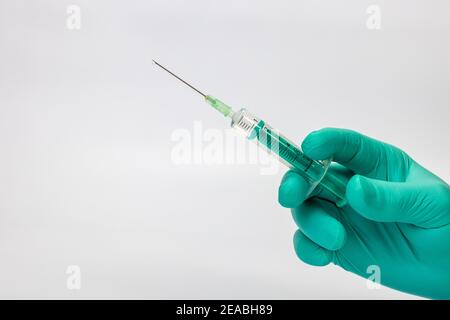 Seringue d'injection à main levée du médecin, gouttes sur l'embout de l'aiguille, photo du symbole, coronavirus, vaccination, Banque D'Images