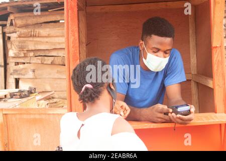 un jeune homme d'affaires africain utilisant une machine de pos Banque D'Images