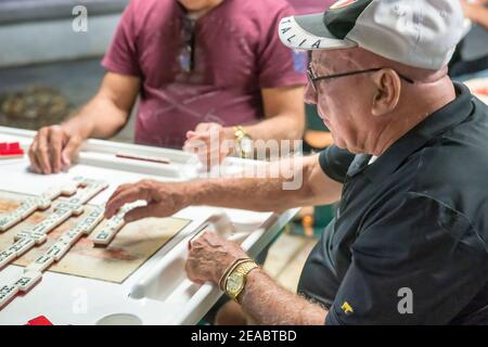 Des résidents cubains de haut niveau jouent des dominos dans un parc de la Calle Ocho, dans la petite Havane de Miami. Banque D'Images