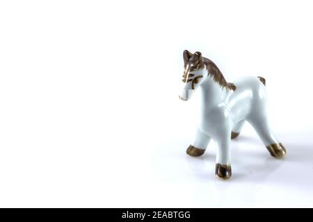 figurine blanche en céramique d'un cheval sur fond blanc Banque D'Images