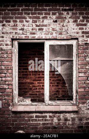 Ancienne fenêtre cassée dans un bâtiment en briques Banque D'Images