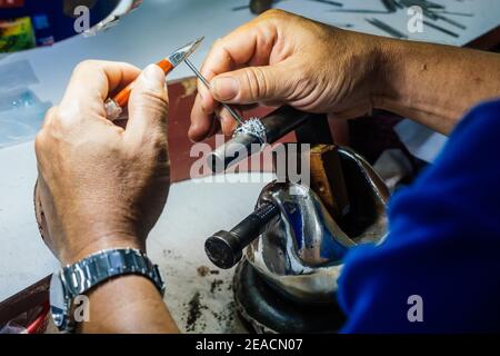 Gros plan d'un orfèvre de la main de fabrication de bague d'argent. Banque D'Images