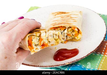 La main tient un morceau de shawarma avec de la viande. Studio photo Banque D'Images