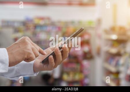 Gros plan sur les mains de l'homme avec un smartphone mobile pour recherche d'internet ou de réseaux sociaux Banque D'Images