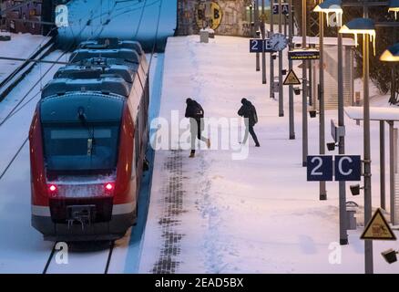 Dortmund, Allemagne. 09e février 2021. Deux passagers montent à bord d'un train régional sur la plate-forme enneigée de la gare signal-Iduna-Park le matin. Toutefois, les annonces de haut-parleurs ont également indiqué que les trains seraient annulés en raison de la météo. Credit: Bernd Thissen/dpa/Alay Live News Credit: dpa Picture Alliance/Alay Live News Banque D'Images