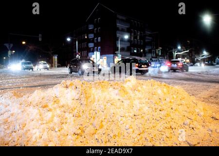 Hanovre, Allemagne. 09e février 2021. Les véhicules traversent une grosse pile de neige à une intersection dans South Town tôt ce matin. Credit: Hauke-Christian Dittrich/dpa/Alay Live News Banque D'Images