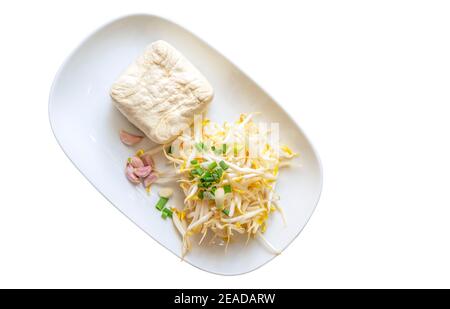 Vue du haut pousses de haricots biologiques, tofu, ail et échalotes dans une assiette blanche. Pousses de haricots, tofu, ail et échalotes de 0rganic isolées en plaque blanche Banque D'Images