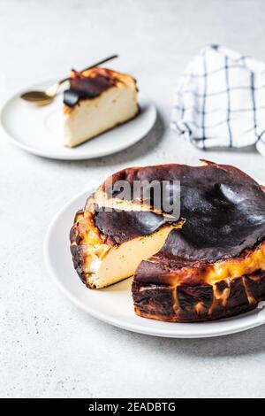 Le basque brûla cheesecake sur une assiette blanche. Concept de cuisine espagnole. Banque D'Images