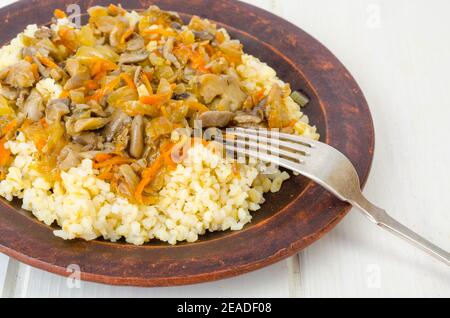 Boulgour bouillie avec des légumes et des champignons cuits, nourriture végétarienne. Studio photo Banque D'Images