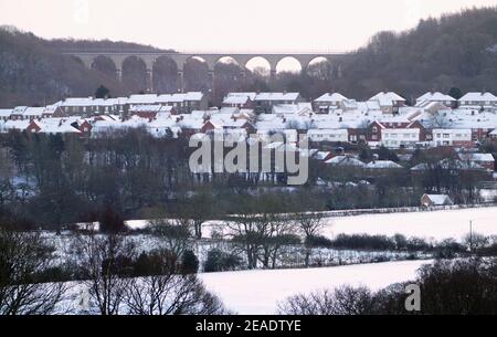 La neige couvre les champs et les toits près de Castleside sur l'A68 dans le comté de Durham, avec le viaduc de Hownsgill au loin. Date de la photo: Mardi 9 février 2021. Banque D'Images