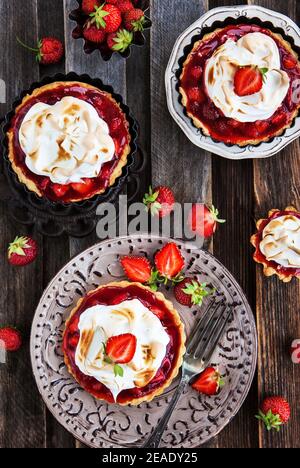 Tartelettes à la fraise meringue sur fond rustique en bois Banque D'Images