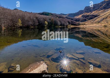 Les rayons du soleil se reflètent sur l'eau du lac de Baccio, Pievepelago, Italie Banque D'Images