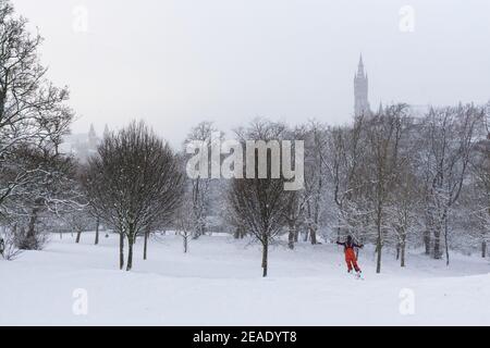 Les gens qui profitent de la neige d'hiver à Kelvingrove Park Glasgow, Royaume-Uni. Enfants en traîneau. Ski dans le parc. Cycliste. Tempête d'hiver. Université de Glasgow. Banque D'Images