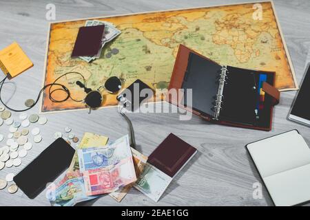 accessoires de voyage. carte du monde, passeports, argent, carte de vaccination internationale, téléphone portable, tablette, casque, lunettes de soleil, appareil photo, agenda et diar Banque D'Images