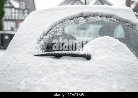 L'essuie-glace arrière nettoie la neige de la petite vitre arrière pare-brise de voiture sur glace fraîche tôt le matin poudre profonde chute de neige Banque D'Images