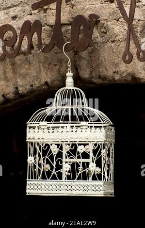 Cage d'oiseaux en métal décoratif suspendue à l'extérieur d'un bâtiment à Malcesine, Lac de Garde, Italie. Banque D'Images