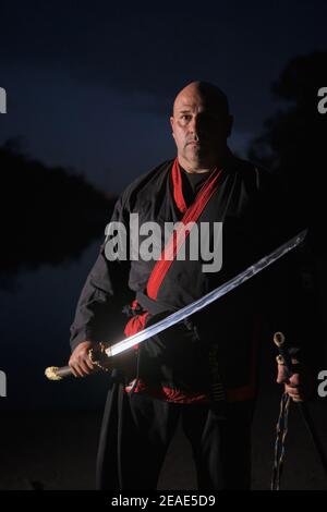 Sipalkido maître de nuit avec katana et lire et noir uniforme Banque D'Images