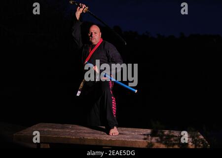 Sipalkido maître de nuit avec katana et lire et noir uniforme Banque D'Images