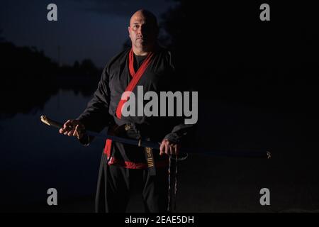 Sipalkido maître de nuit avec katana et lire et noir uniforme Banque D'Images