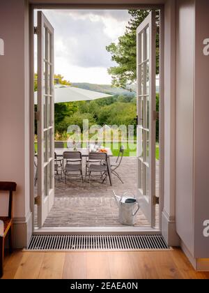 Des fenêtres à deux fenêtres donnent sur un coin salon sur la terrasse d'une maison contemporaine à Sussex, au Royaume-Uni Banque D'Images