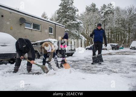 Glasgow, Écosse, Royaume-Uni. 9 février 2021. Photo : les gens déneigement et la glace compactée après que les petites routes ont été laissées à l'écart et qu'elles ont été labourées par le Conseil du Lanarkshire du Nord, comme après la tempête Darcy a déposé près d'un pied de neige sur des chemins de nuit bloquant et se déversant sur les murs, les portes, les bennes à roues. La nuit précédente a également vu la neige tomber, mais pas autant que la nuit dernière. Les températures glaciales se sont maintenues autour de -1C, la nuit dernière étant la plus froide jusqu'à présent. Crédit : Colin Fisher/Alay Live News Banque D'Images