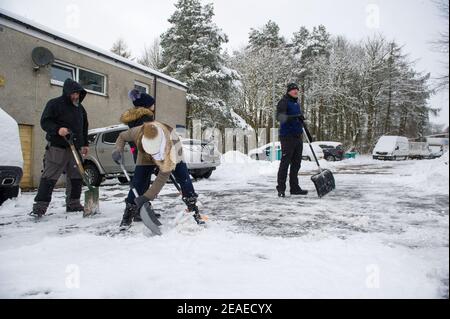 Glasgow, Écosse, Royaume-Uni. 9 février 2021. Photo : les gens déneigement et la glace compactée après que les petites routes ont été laissées à l'écart et qu'elles ont été labourées par le Conseil du Lanarkshire du Nord, comme après la tempête Darcy a déposé près d'un pied de neige sur des chemins de nuit bloquant et se déversant sur les murs, les portes, les bennes à roues. La nuit précédente a également vu la neige tomber, mais pas autant que la nuit dernière. Les températures glaciales se sont maintenues autour de -1C, la nuit dernière étant la plus froide jusqu'à présent. Crédit : Colin Fisher/Alay Live News Banque D'Images