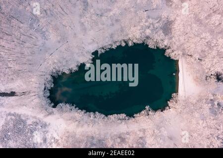 Szilvásvárad, Hongrie - vue aérienne du célèbre lac supérieur également connu sous le nom de Sipovics tengerzem avec de l'eau turquoise cristalline. Forêt d'hiver enneigée Banque D'Images