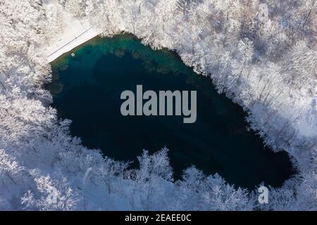 Szilvásvárad, Hongrie - vue aérienne du célèbre lac supérieur également connu sous le nom de Sipovics tengerzem avec de l'eau turquoise cristalline. Forêt d'hiver enneigée Banque D'Images