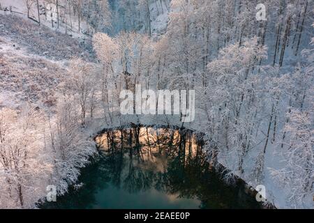 Szilvásvárad, Hongrie - vue aérienne du célèbre lac supérieur également connu sous le nom de Sipovics tengerzem avec de l'eau turquoise cristalline. Forêt d'hiver enneigée Banque D'Images