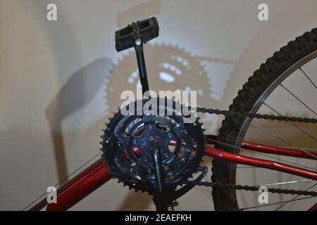 Vélo. Roue dentée, chaîne, pédale, pneu, rayons et partie du cadre d'un vélo rouge pour usage domestique ou sportif, zoom photo, lumière LED bleue, Brésil, S. Banque D'Images