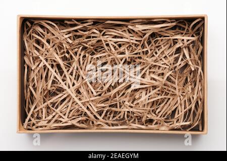 Ouvrez la boîte marron avec du papier déchiqueté au-dessus de la vue de dessus isolée Banque D'Images