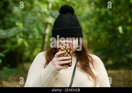 Jeunes femmes avec chapeau d'hiver sur l'utilisation de l'iPhone Banque D'Images