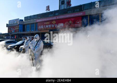 Tonghua, province chinoise de Jilin. 9 février 2021. Les membres du personnel désinfectent la place devant la gare de Tonghua, dans la province de Jilin, au nord-est de la Chine, le 9 février 2021. Credit: Xu Chang/Xinhua/Alay Live News Banque D'Images