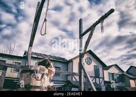 Une femme pleure sur l'échafaudage de la place de la ville avec des galws pour les exécutions Banque D'Images