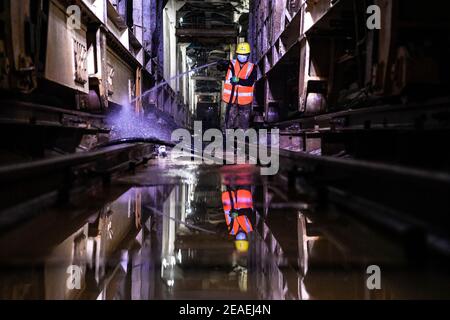 (210209) -- ZHONGNING, 9 février 2021 (Xinhua) -- UN travailleur nettoie les boues à l'intérieur d'un tunnel traversant la rivière jaune dans le comté de Zhongning, Zhongwei ville du nord-ouest de la Chine, Ningxia hui Autonomous Reigon, 9 février 2021. Plus de 100 travailleurs sont encore en service dans le tunnel pour assurer le développement du projet à temps malgré le prochain Festival du printemps, ou le nouvel an lunaire chinois. Ce tunnel, le deuxième à traverser la rivière jaune à Ningxia, s'inscrit dans le cadre d'un plus grand projet visant à fournir un service de chauffage aux résidents de Zhongning. (Xinhua/Feng Kaihua) Banque D'Images