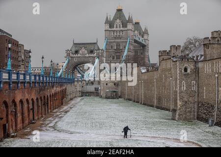 Londres, Royaume-Uni. 9 février 2021. Un homme de terrain fourche la douve enneigée entourant la Tour de Londres actuellement recouverte de neige alors que les températures glaciales frappent Londres pendant la tempête Darcy. Londres, Angleterre. 09e février 2021 crédit : Jeff Gilbert/Alamy Live News Banque D'Images