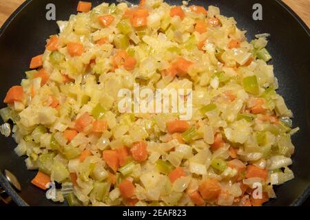Une sélection d'ingrédients de cuisson mélangés friture dans une poêle comprenant des carottes, des oignons de printemps et du céleri. Banque D'Images