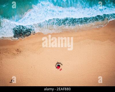 Vue verticale de l'été plage vacances concept avec bleu vagues de l'océan et deux touristes marchant et appréciant sur le sable seul - concept o Banque D'Images