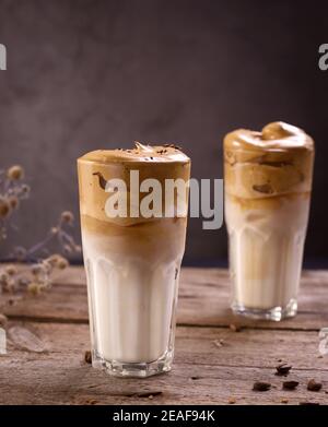 Café Dalgona. Boisson fouettée à glacer avec café instantané populaire en Corée cocktail crémeux dans de grands verres. Photographie de nourriture sombre Banque D'Images